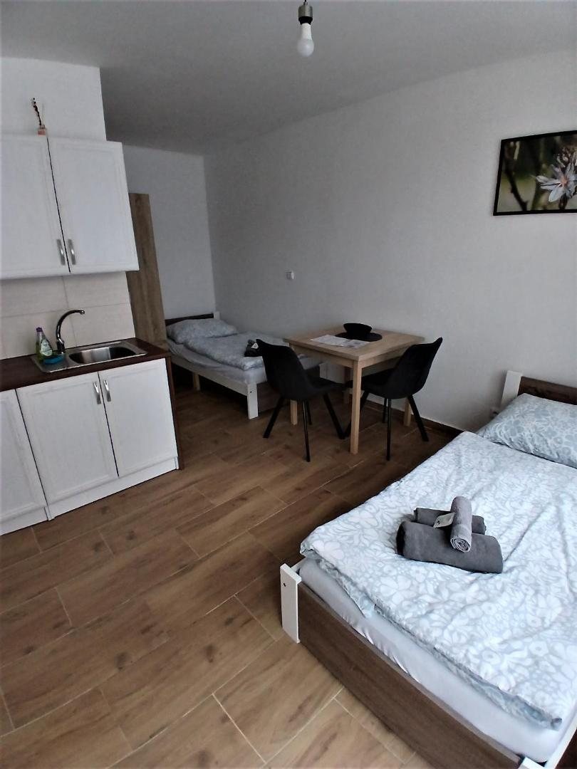 Postele s ručníky a kuchyňská linka